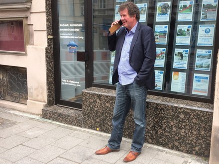 Fritz N. Osterried telefoniert vor seinem Immobilienbüro in der Max-Planck-Straße in München