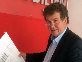Immobilien-Sachverständiger Osterried 2016 mit einem Bauplan in seinem Büro